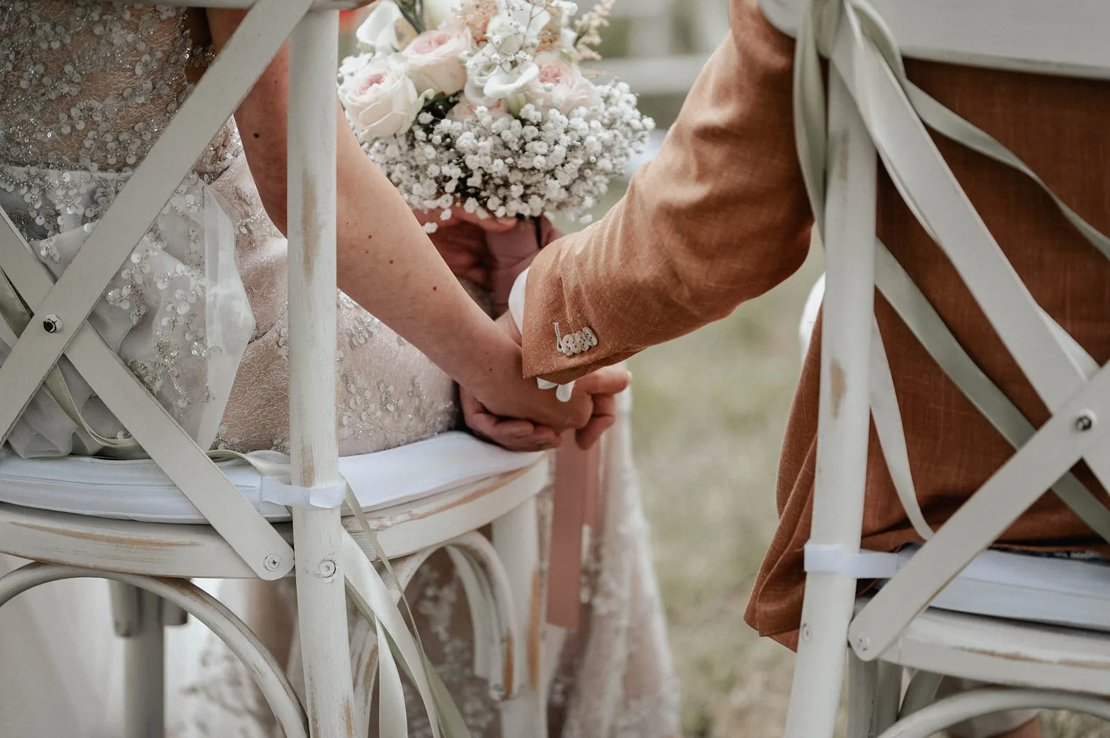 Detailaufnahme: Braut und Bräutigam halten sich während der freien Trauung an den Händen – Spessarthof, Aura im Sinngrund (Landkreis Main-Spessart, Bayern).