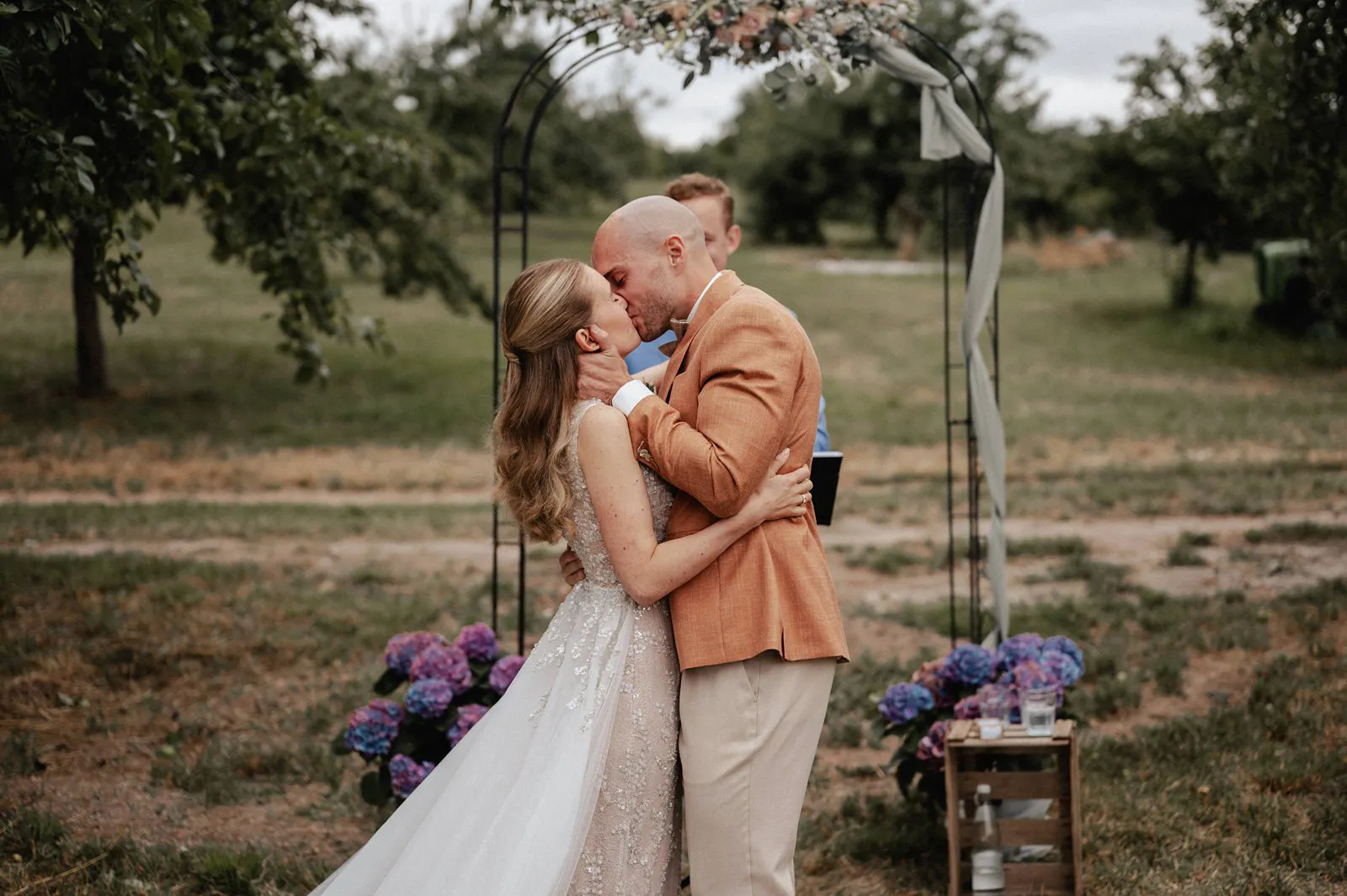 Kuss des Brautpaars während der freien Trauung unter dem Traubogen – Spessarthof, Aura im Sinngrund (Sinngrund, Bayern).