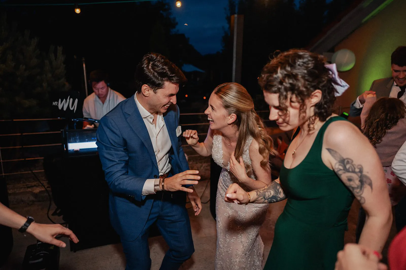 Abendliche Party: Die Braut lacht und tanzt mit Gästen auf der Tanzfläche, Musik im Hintergrund – Spessarthof, Aura im Sinngrund, Bayern (Unterfranken).