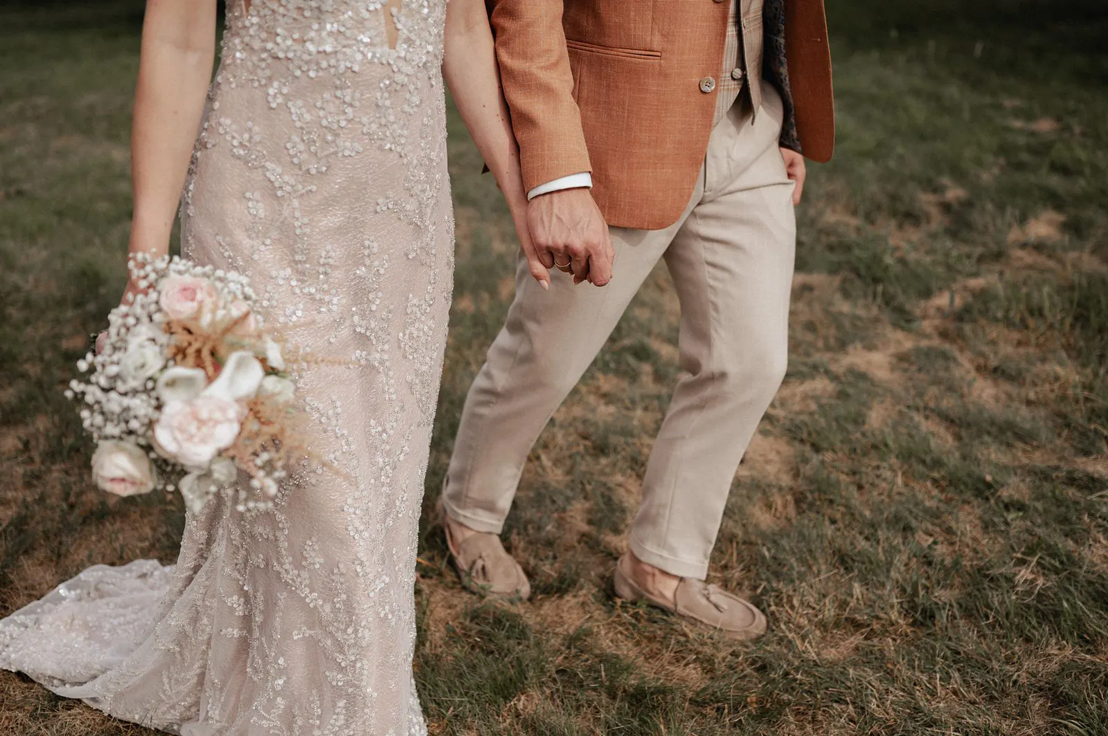 Detailaufnahme vom Brautpaar Hand in Hand mit Brautstrauß am Spessarthof in Aura im Sinngrund, Bayern – Hochzeit im Landkreis Main-Spessart.