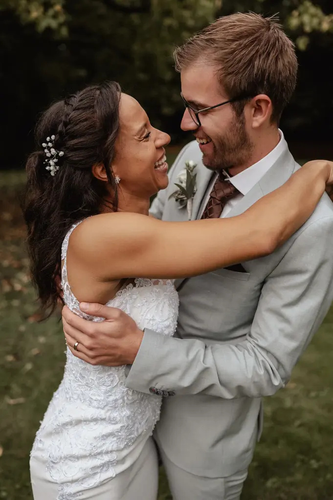 Braut und Bräutigam lachen sich in den Armen an – standesamtliche Hochzeit an der Villa Wuppermann in Leverkusen.